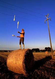 "un giocoliere, l'alba, la luna e un palo della luce"