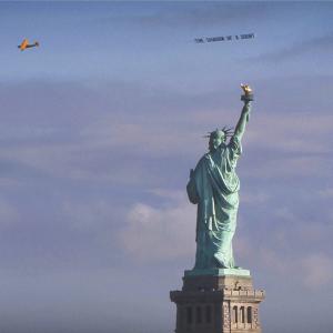 'The Shadow of a Doubt', airplane banner circling The Statue of Liberty; from the project 'Severe Clear', 2014