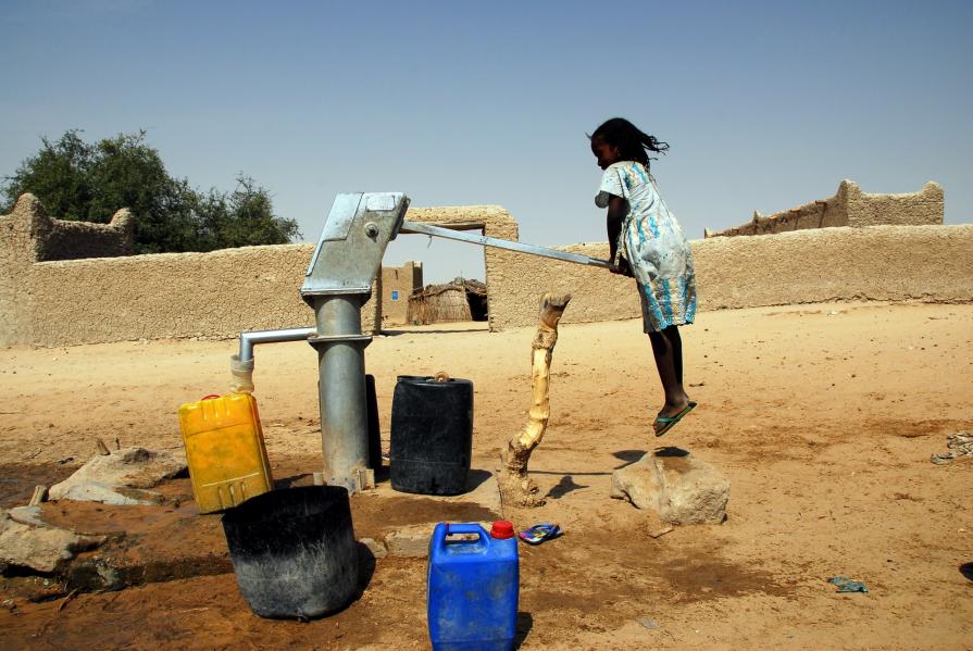 Bambina sospesa alla pompa dell'acqua