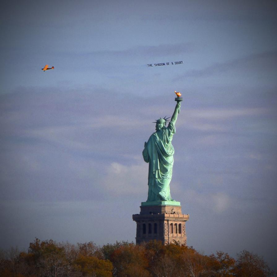 'The Shadow of a Doubt', airplane banner circling The Statue of Liberty; from the project 'Severe Clear', 2014