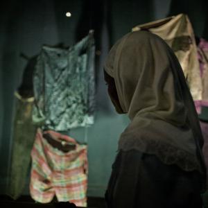 A student gazes on genocide victim's clothing