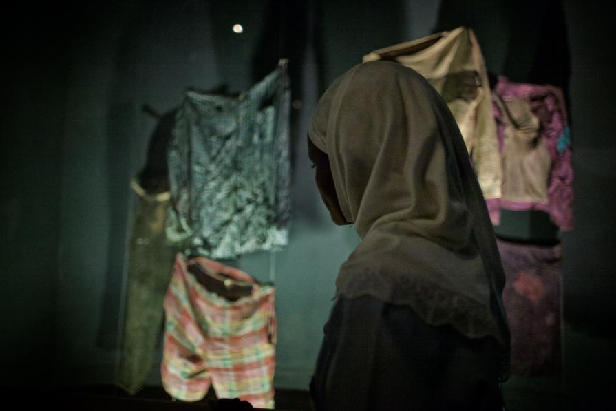 A student gazes on genocide victim's clothing